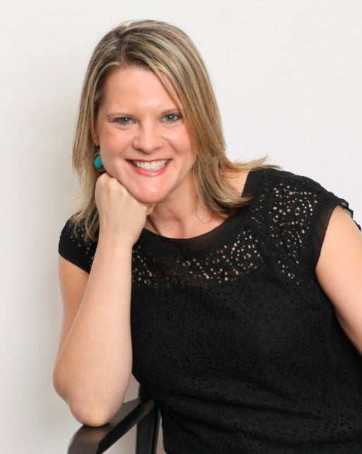 A smiling blonde woman resting her chin on her hand, wearing a black sleeveless textured top and turquoise earrings, set against a plain light gray background.Berit Elizabeth is a mental health tech founder, emotional intelligence trainer, and creator of Emotive Agility Training, an emotional fitness curriculum based on Richard Schechner's rasaboxes for actors. A lifelong learner, Berit's work sits at the intersection of theater, neuroscience, and cultural context. 