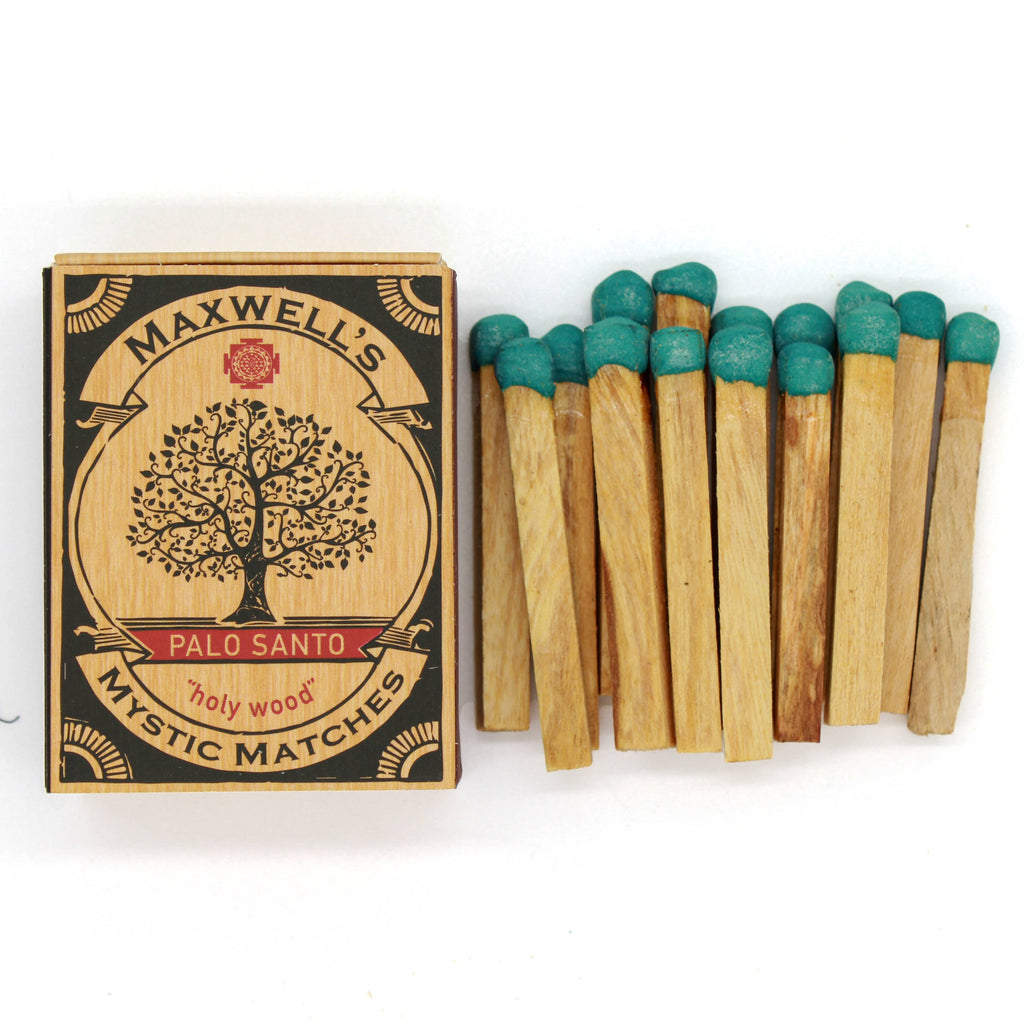 Maxwell's Palo Santo matches with wooden matches and green tops on a white background