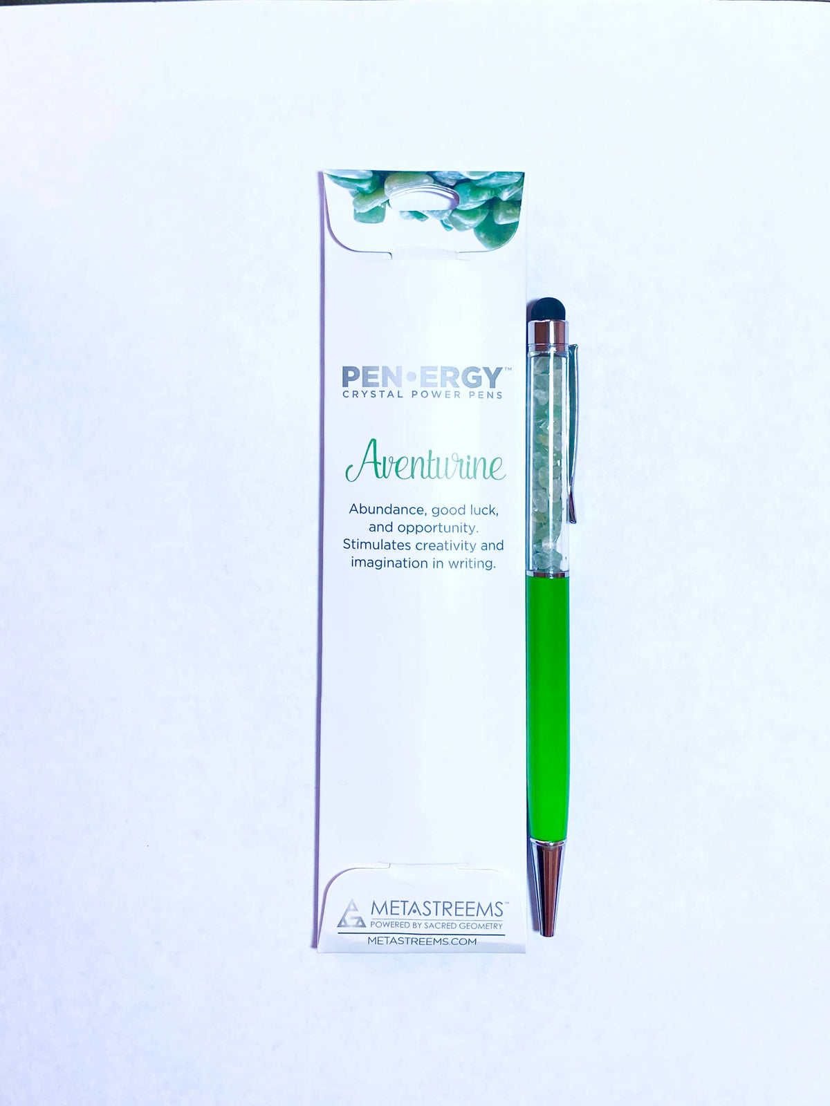 A green and silver PenEnergy crystal ball pen standing next to its white packaging box on a white background.