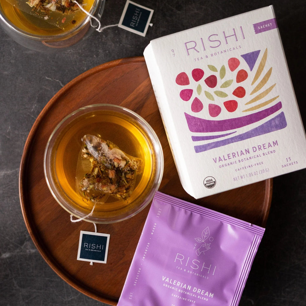 Rishi Valerian Dream tea packaging with a glass of tea on a wooden tray.